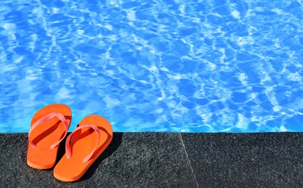 Flip flops by an Oakville pool. Keep feet wart free with foot clinic and chiropodist help in oakville.