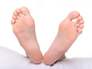 Bare Feet under covers showing oakville Foot Clinic, massage, RMT