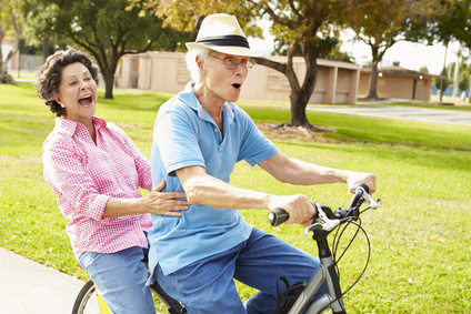 Seniors riding bikes in park showing Oakville Physio